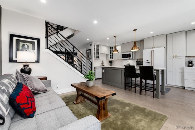 living room with light hardwood / wood-style floors and sink