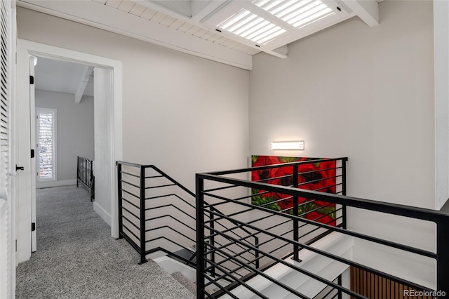 hall featuring carpet flooring and beamed ceiling