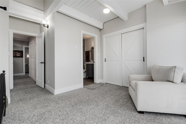 living area with beam ceiling, carpet, and wood ceiling