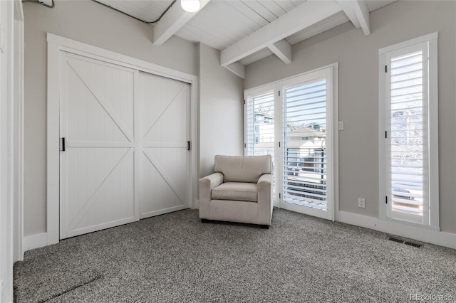 unfurnished room featuring carpet and vaulted ceiling with beams