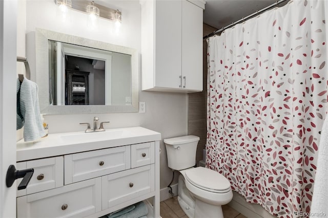 bathroom with tile patterned floors, vanity, toilet, and curtained shower