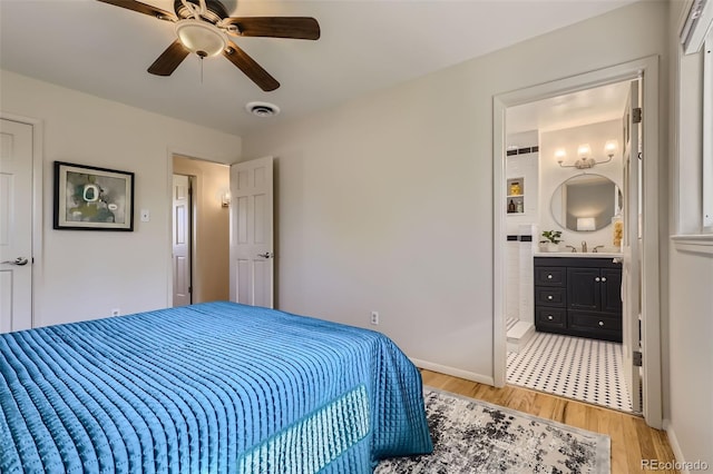 bedroom featuring sink, connected bathroom, ceiling fan, and light hardwood / wood-style flooring