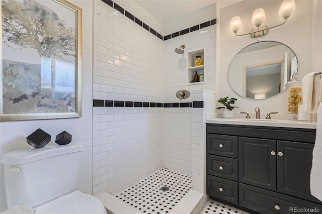 bathroom featuring vanity, toilet, and tiled shower