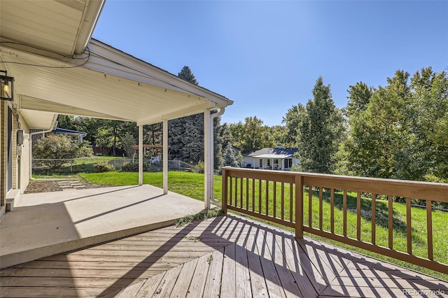 wooden terrace with a lawn and a patio