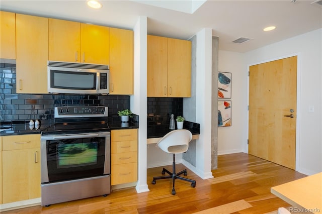 1700 Bassett St Unit 1119, Denver, CO 80202 - kitchen featuring stainless steel appliances, light wood-style floors, dark countertops, backsplash, and recessed lighting