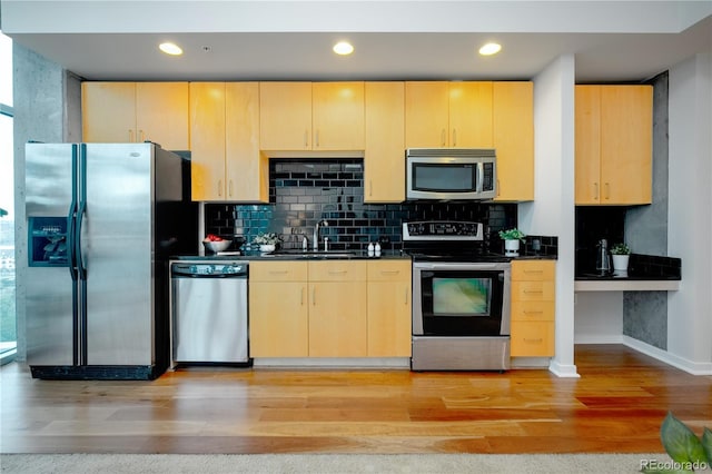 1700 Bassett St Unit 1119, Denver, CO 80202 - kitchen with stainless steel appliances, a sink, light brown cabinetry, dark countertops, and recessed lighting