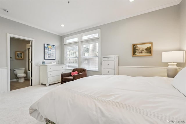 carpeted bedroom with crown molding and ensuite bathroom