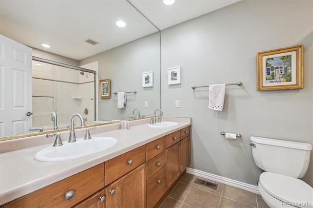 bathroom with tile patterned floors, toilet, a shower with door, and vanity