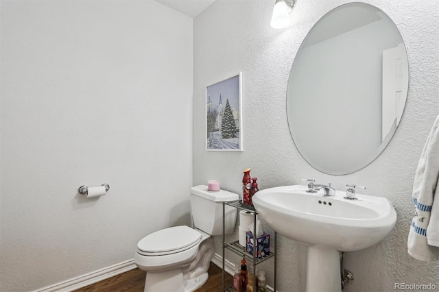 bathroom with hardwood / wood-style floors and toilet