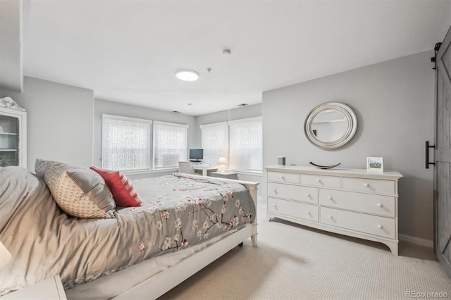 carpeted bedroom featuring a barn door