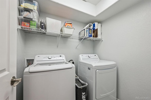 clothes washing area featuring separate washer and dryer