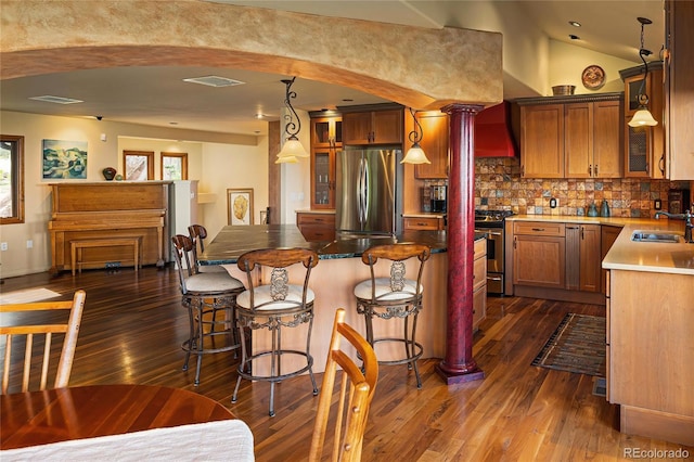 8932 Eastridge Rd, Golden, CO 80403 - kitchen with appliances with stainless steel finishes, dark wood-style flooring, decorative backsplash, a sink, and vaulted ceiling