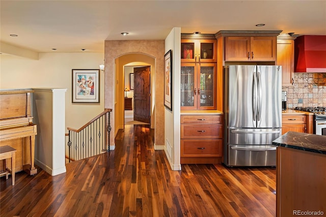 8932 Eastridge Rd, Golden, CO 80403 - kitchen with appliances with stainless steel finishes, arched walkways, dark wood-style floors, glass insert cabinets, and tasteful backsplash