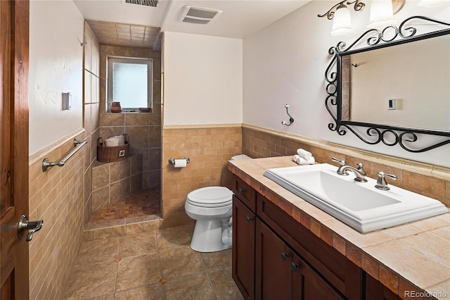 8932 Eastridge Rd, Golden, CO 80403 - full bath with tile walls, toilet, a tile shower, vanity, and wainscoting