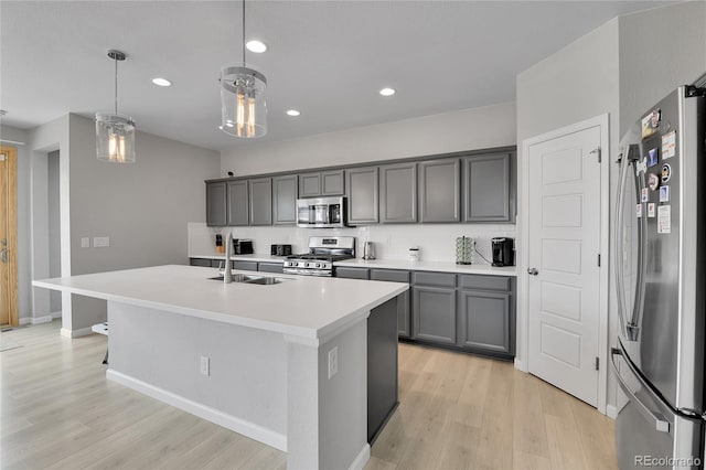 27853 E 8th Ave, Aurora, CO 80018 - kitchen featuring stainless steel appliances, light wood-style floors, a kitchen island with sink, recessed lighting, and light countertops
