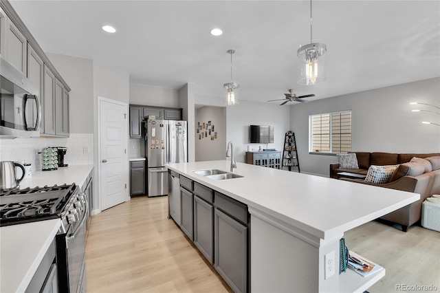27853 E 8th Ave, Aurora, CO 80018 - kitchen featuring open floor plan, appliances with stainless steel finishes, light wood-style flooring, gray cabinetry, and light countertops