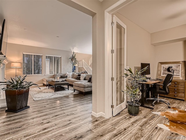 hall with stairs, baseboards, and wood finished floors