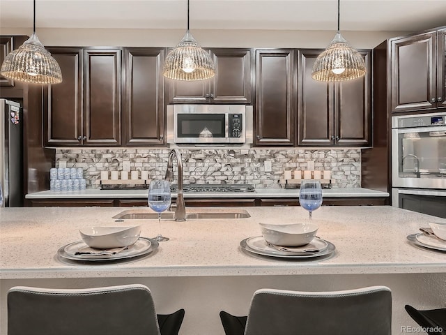 kitchen with a sink, dark brown cabinetry, backsplash, and stainless steel appliances