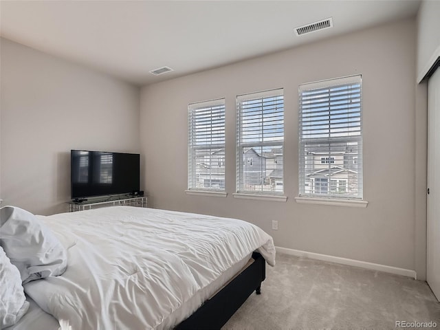 carpeted bedroom featuring visible vents and baseboards