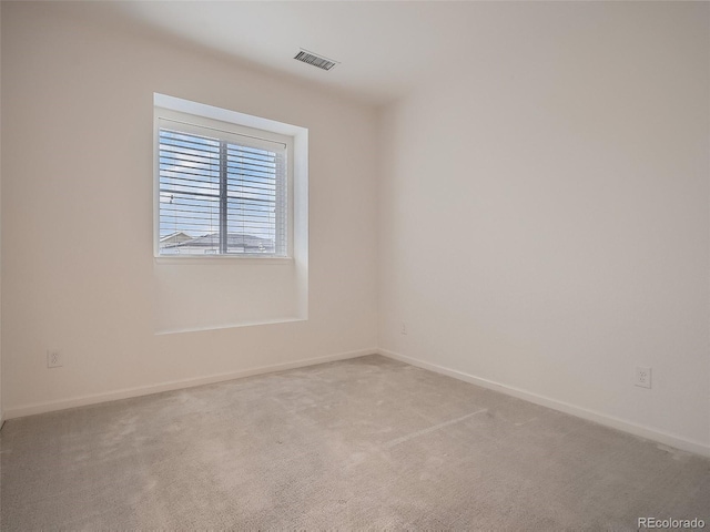 empty room featuring carpet flooring, baseboards, and visible vents