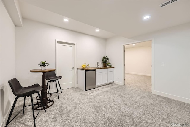 living area with visible vents, baseboards, indoor wet bar, light carpet, and recessed lighting