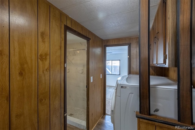 laundry room with laundry area, independent washer and dryer, and wooden walls