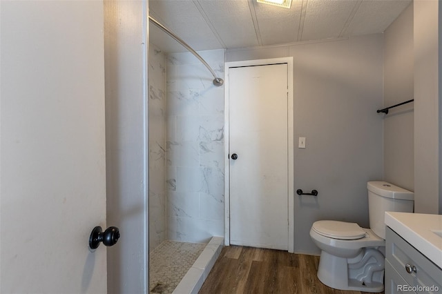 full bathroom with toilet, a shower stall, wood finished floors, and vanity