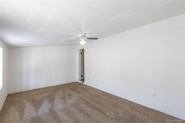 carpeted empty room with ceiling fan and a textured ceiling