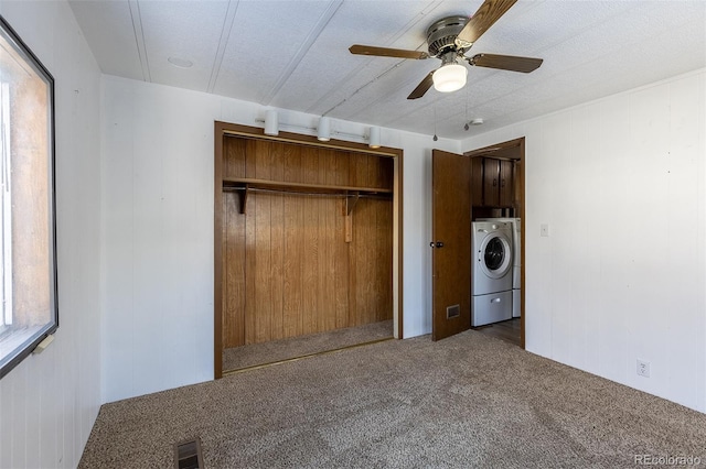 unfurnished bedroom featuring carpet flooring, visible vents, a ceiling fan, a closet, and washer / dryer