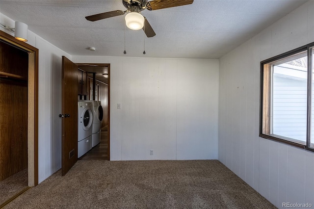 unfurnished bedroom with a ceiling fan, dark colored carpet, and separate washer and dryer