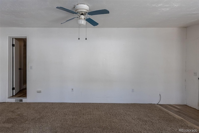 unfurnished room with carpet floors, visible vents, a textured ceiling, and a ceiling fan