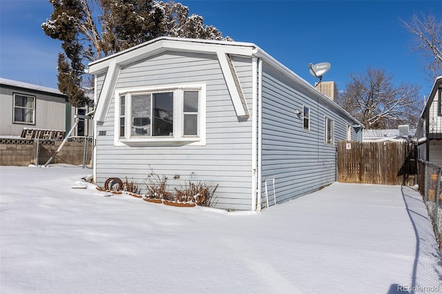 snow covered property featuring fence