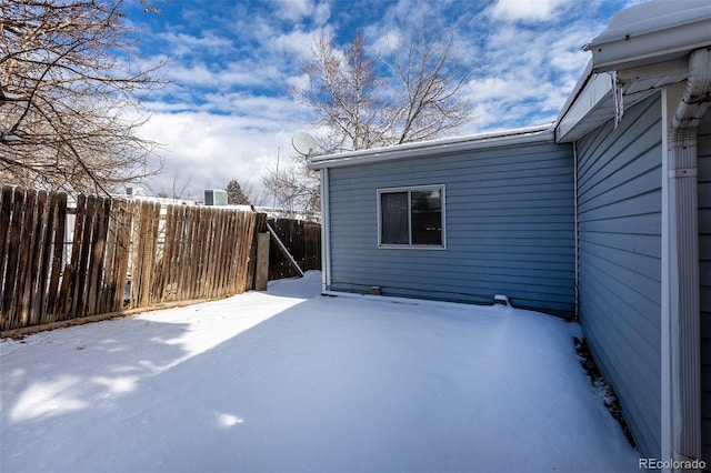 snow covered patio featuring fence