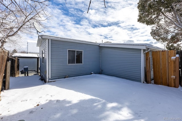 snow covered property with fence