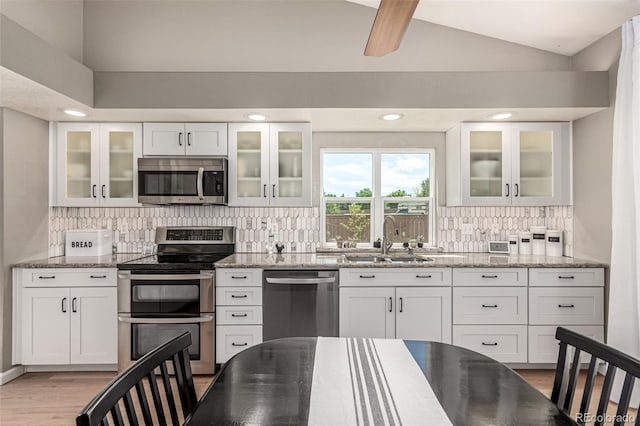 392 Driftwood Cir, Lafayette, CO 80026 - kitchen with stainless steel appliances, lofted ceiling, light wood-type flooring, white cabinetry, and recessed lighting