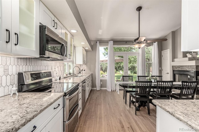 392 Driftwood Cir, Lafayette, CO 80026 - kitchen with appliances with stainless steel finishes, decorative backsplash, white cabinets, and recessed lighting