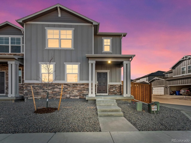 view of front of home with a gate, board and batten siding, and stone siding