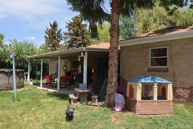 2885 Quay St, Wheat Ridge, CO 80033 - back of property with brick siding, a patio area, and a lawn
