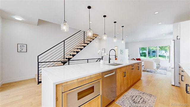 2405 S Franklin, Denver, CO 80210 - kitchen featuring appliances with stainless steel finishes, light wood-style flooring, a center island with sink, light countertops, and recessed lighting