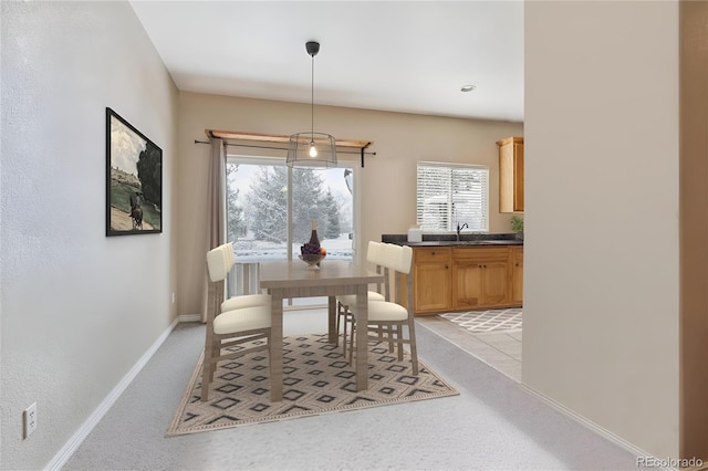 dining area featuring light carpet and sink