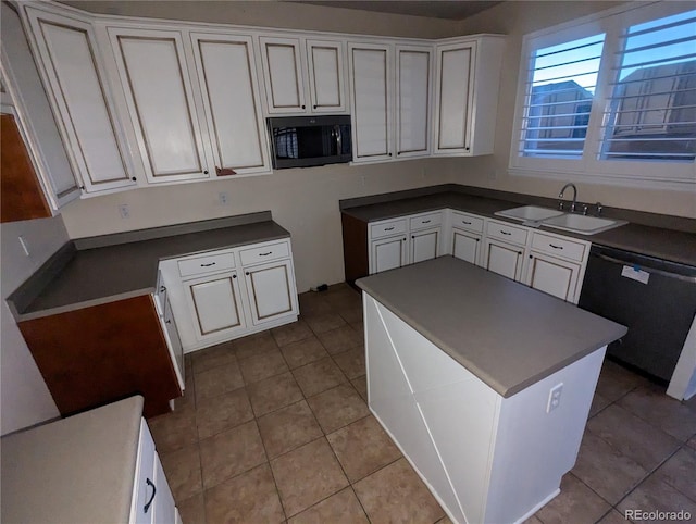 kitchen with sink, light tile patterned floors, white cabinets, and dishwashing machine