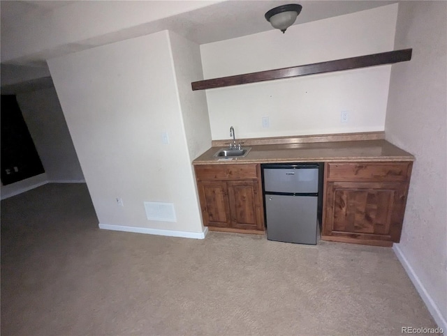 bar featuring stainless steel refrigerator and sink