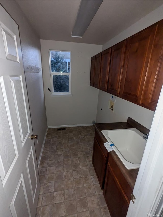 laundry room featuring sink, washer hookup, and cabinets