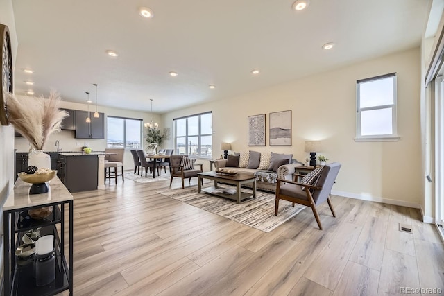 living room featuring an inviting chandelier and light hardwood / wood-style flooring