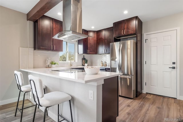 15 Hazel Ct, Denver, CO 80219 - kitchen with stainless steel fridge with ice dispenser, island range hood, a peninsula, a breakfast bar area, and decorative backsplash