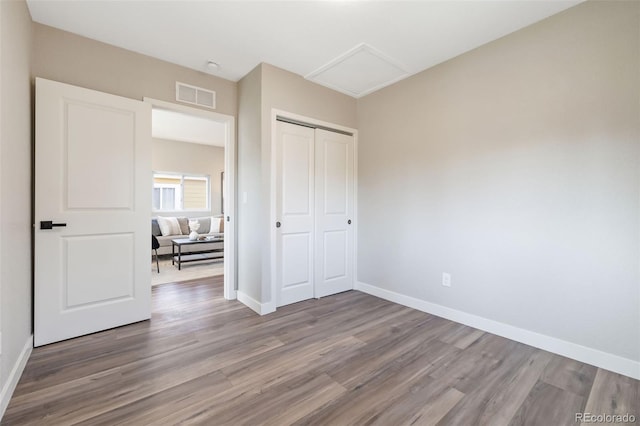 15 Hazel Ct, Denver, CO 80219 - unfurnished bedroom featuring wood finished floors, attic access, baseboards, and a closet