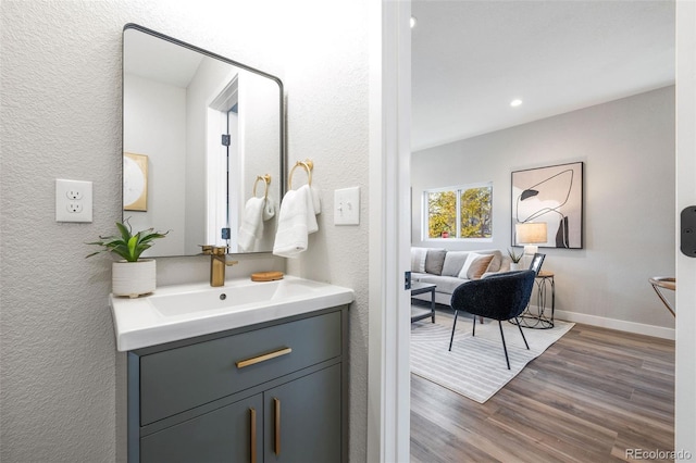 15 Hazel Ct, Denver, CO 80219 - bathroom featuring a textured wall, wood finished floors, vanity, baseboards, and recessed lighting