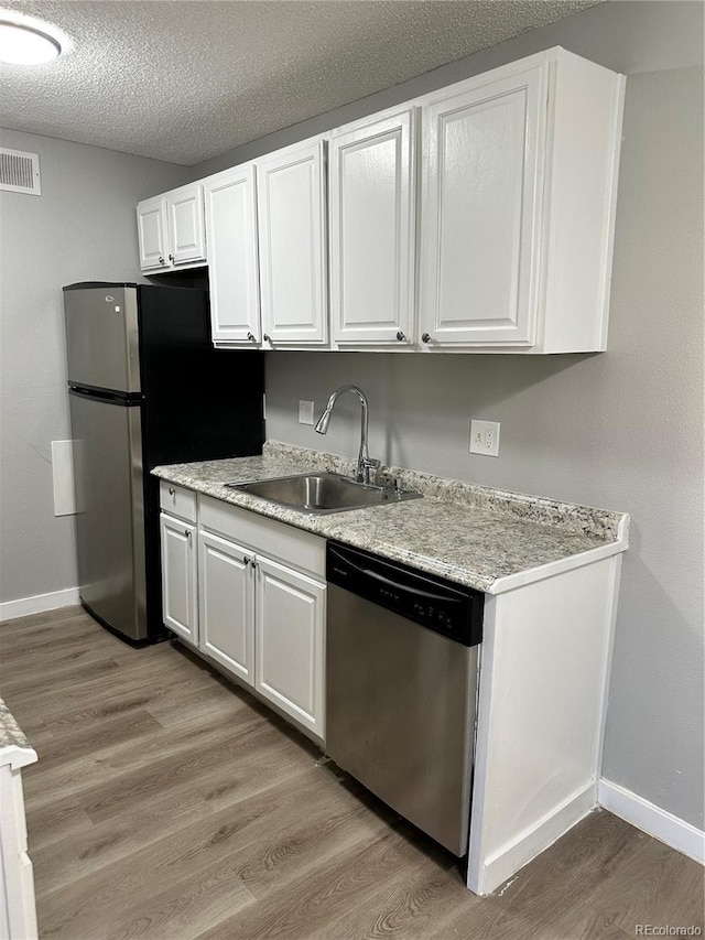 10211 Ura Ln Unit 7-108, Thornton, CO 80260 - kitchen with stainless steel appliances, a sink, white cabinetry, baseboards, and a textured ceiling