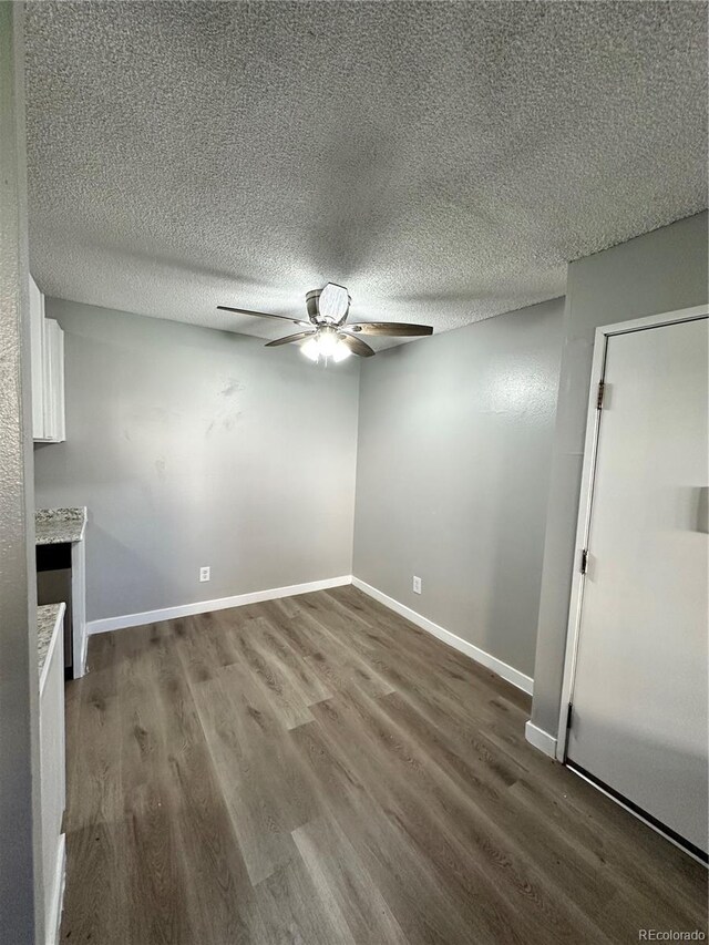 10211 Ura Ln Unit 7-108, Thornton, CO 80260 - unfurnished living room featuring a ceiling fan, dark wood-type flooring, baseboards, and a textured ceiling