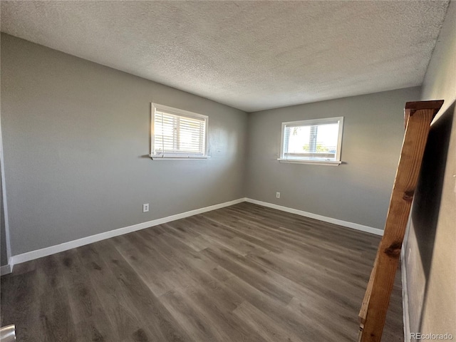 10211 Ura Ln Unit 7-108, Thornton, CO 80260 - spare room with a textured ceiling, dark wood-style flooring, and baseboards